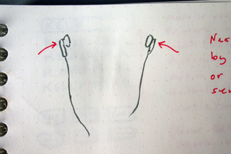 Sketch of a capacitive touch sensor in each earbud, detecting when the ear is covered
